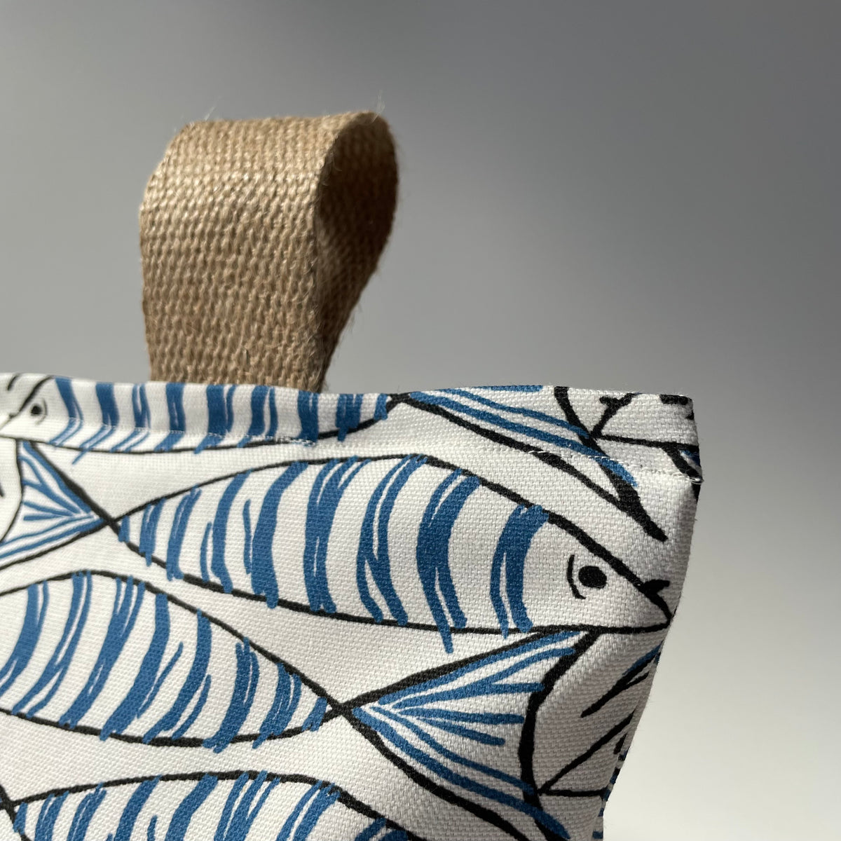 Sardine Fish White, Blue and Black Fabric Doorstop with thick jute handle on top.