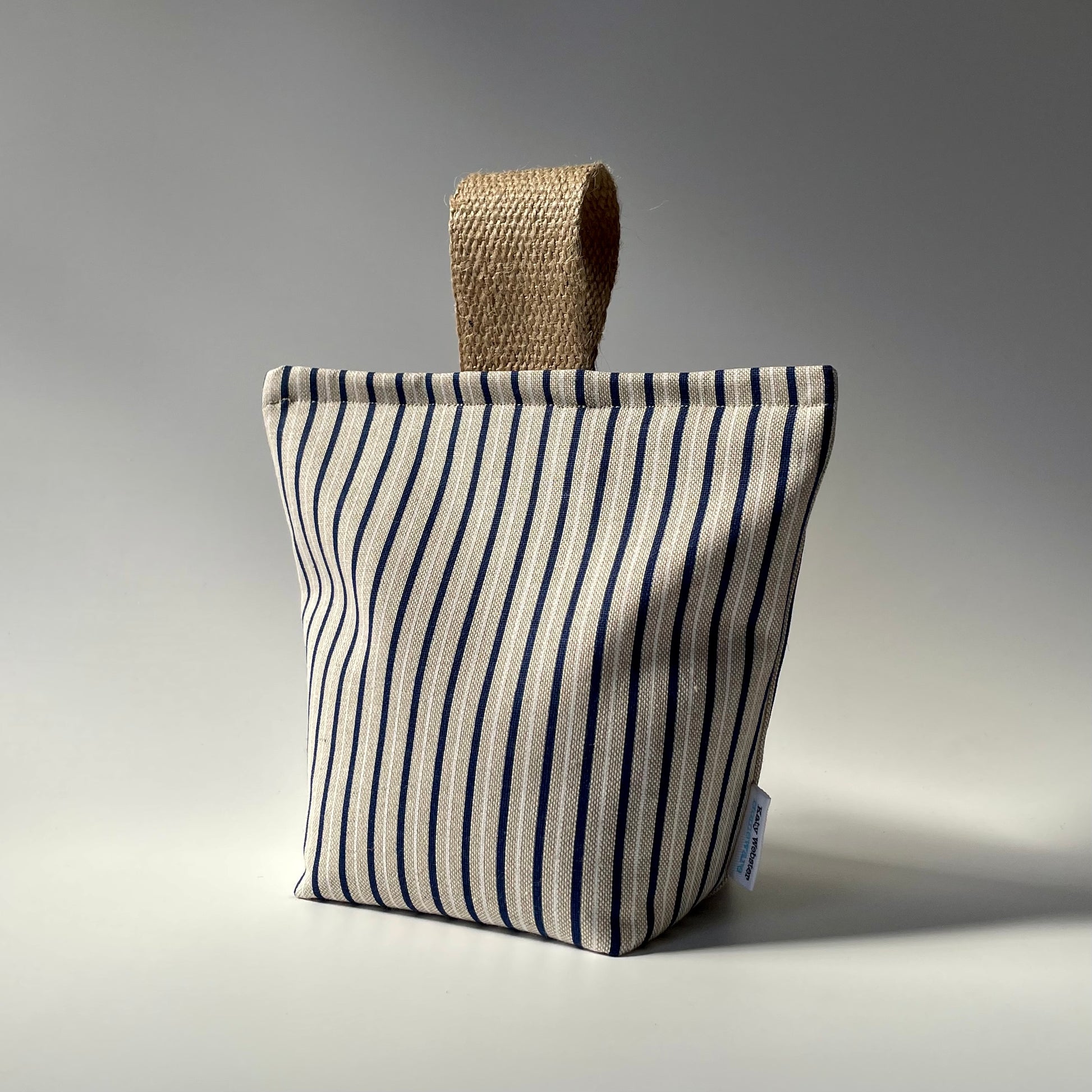 Blue and white stripe on natural background fabric doorstopper with jute handle.