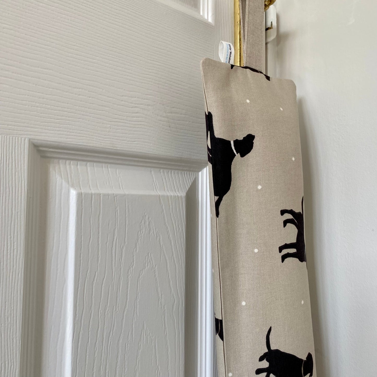 Black Lab dog patterned beige, white and black heavy draught excluder with washable cover and hanging loop.