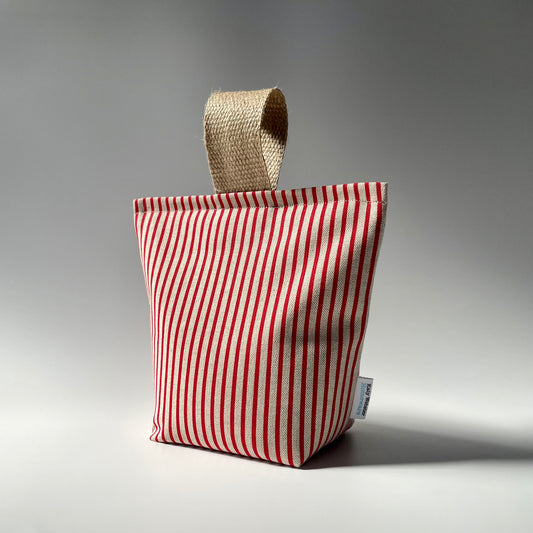 Red pinstripe on natural fabric doorstop with thick jute handle on top.