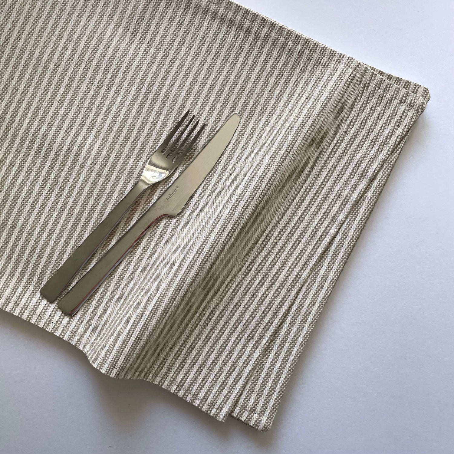 Beige and White stripe natural linen look reversible placemat with cutlery for scale