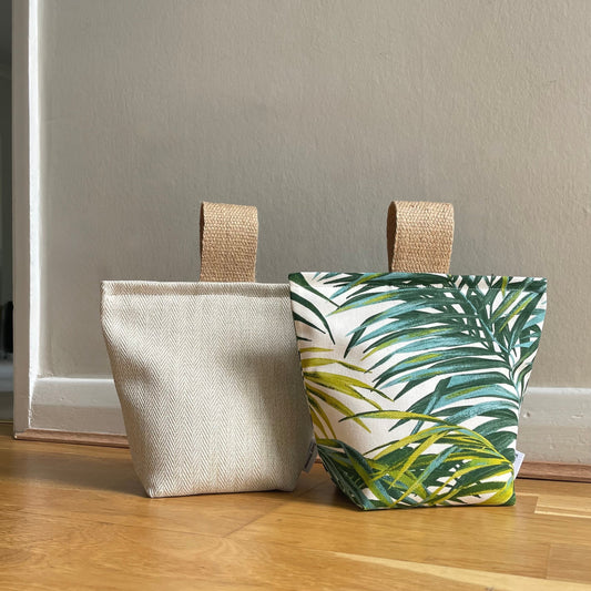 katywebsterhomeware 2kg sand-filled doorstops in palm leaf print and cream herringbone fabric with jute handles.
