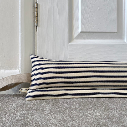 A striped navy blue and cream horizontal stripes, resting on a grey carpet in front of a white panelled door.