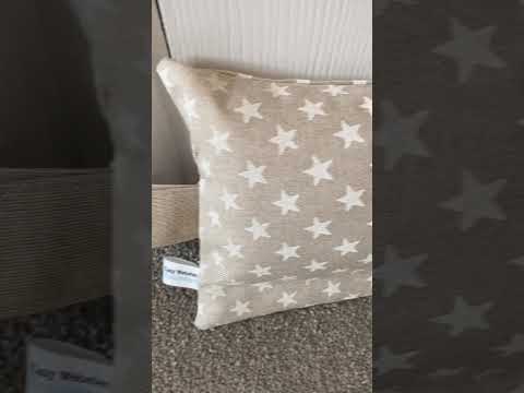 Heavy draught excluder with washable beige and white star print cover and hanging loop.